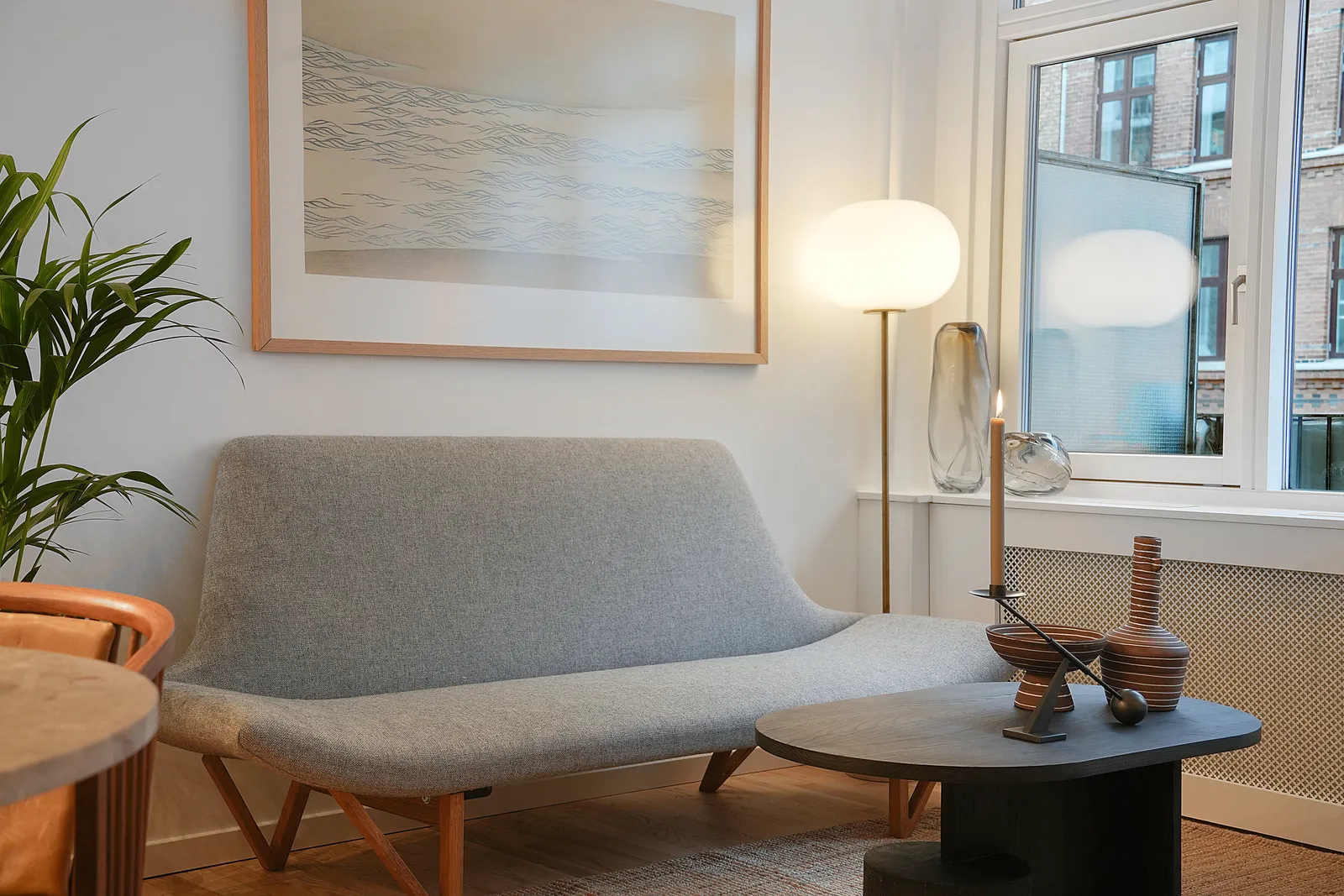 Lys stue med sofa, kunst og planter